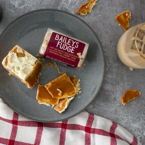 Lifestyle image of a baileys fudge bar with a glass of baileys