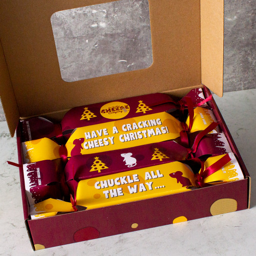 A Box of 4 Luxury Christmas Crackers filled with cheese, crackers, chutney, a Christmas hat and a joke.