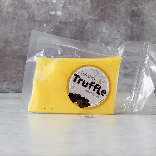 An image of the Truffle Cheddar, made from a creamy cheddar base and blended with luxourious and rich black truffles, available to purchase from The Chuckling Cheese Company.